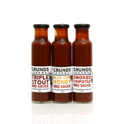 Three bottles of Grund's Gourmet BBQ Sauce on a white background