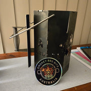 Black metal BBQ smoker with Smokey BBQ Bits Australia logo on a table.