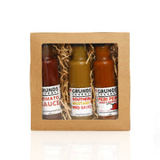 Three bottles of Grunds Gourmet sauces in a cardboard gift box on a white background