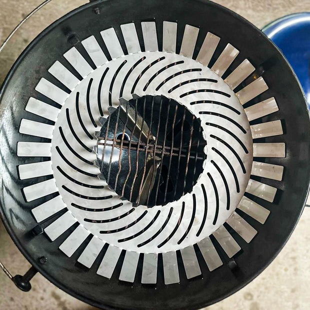 Close-up of a metal fire pit grate with a blue fire starter tool in the background.