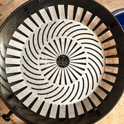 Barbecue grill with a ceramic cooking grid and a blue lighter on a wooden surface