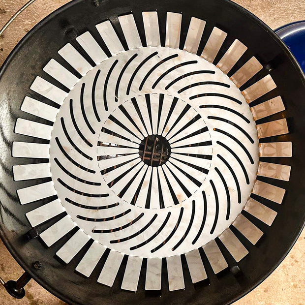 Barbecue grill with a ceramic cooking grid and a blue lighter on a wooden surface