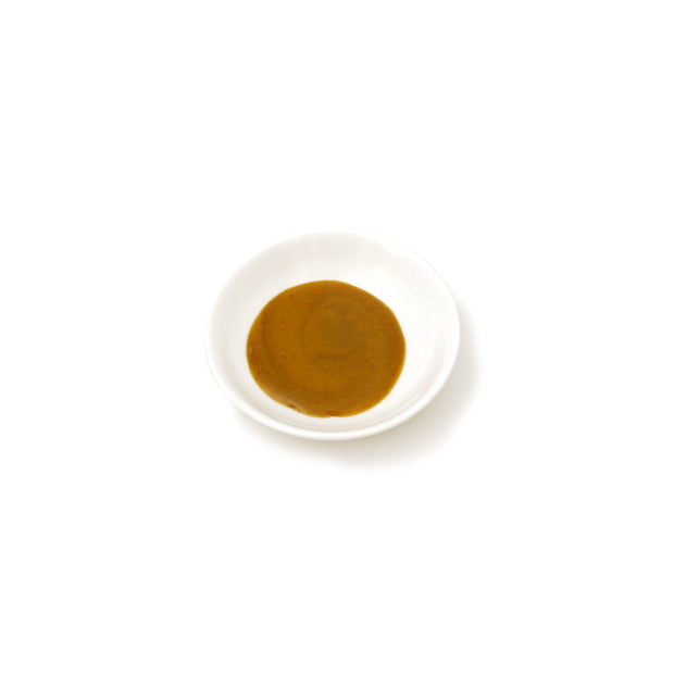 Small white bowl with brown substance on a white background