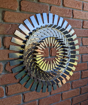 Decorative metal wall art with a spiral design on a brick wall