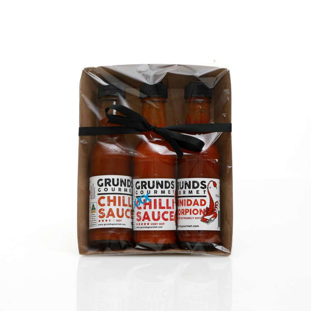 Three bottles of Grund's Gourmet Chilli Sauce in a clear package on a white background